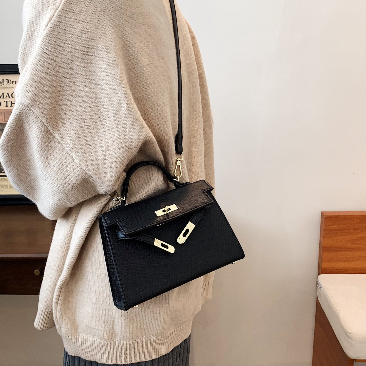 A woman carrying a small square bag with a lock