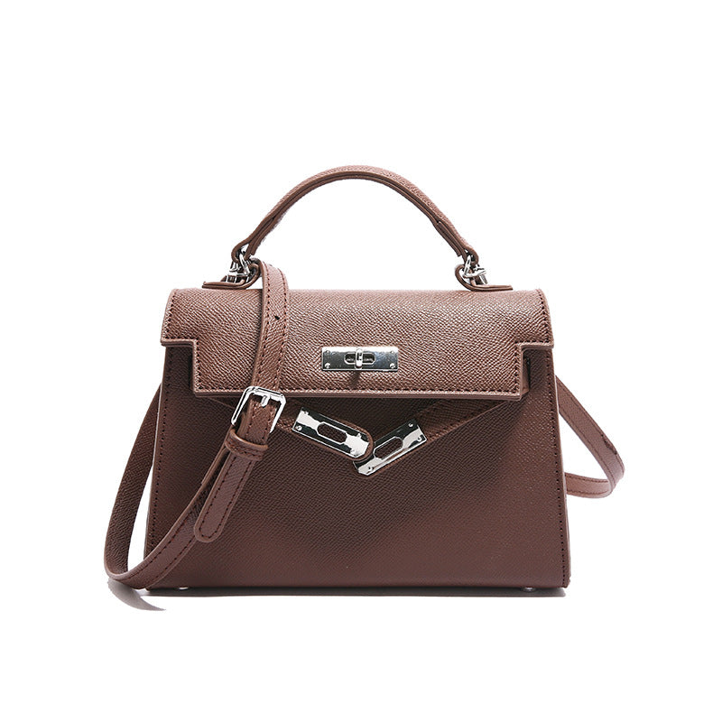 A woman carrying a small square bag with a lock