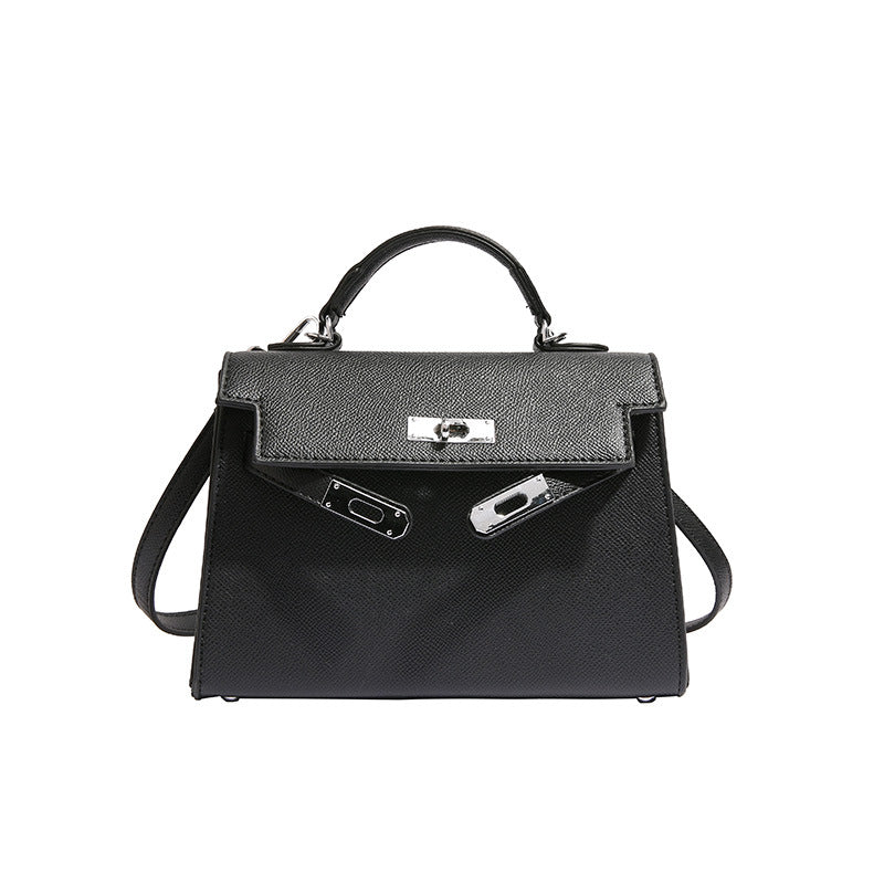 A woman carrying a small square bag with a lock