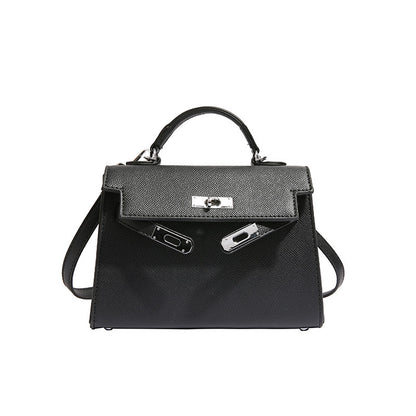 A woman carrying a small square bag with a lock