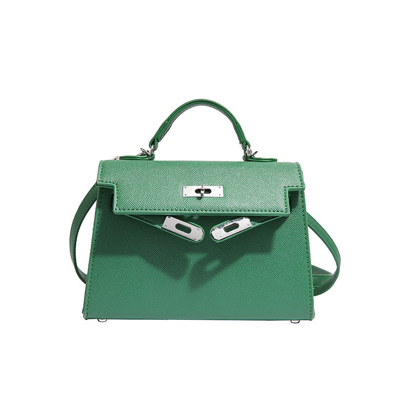 A woman carrying a small square bag with a lock