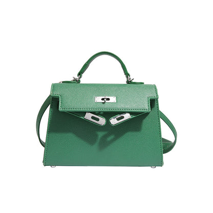 A woman carrying a small square bag with a lock